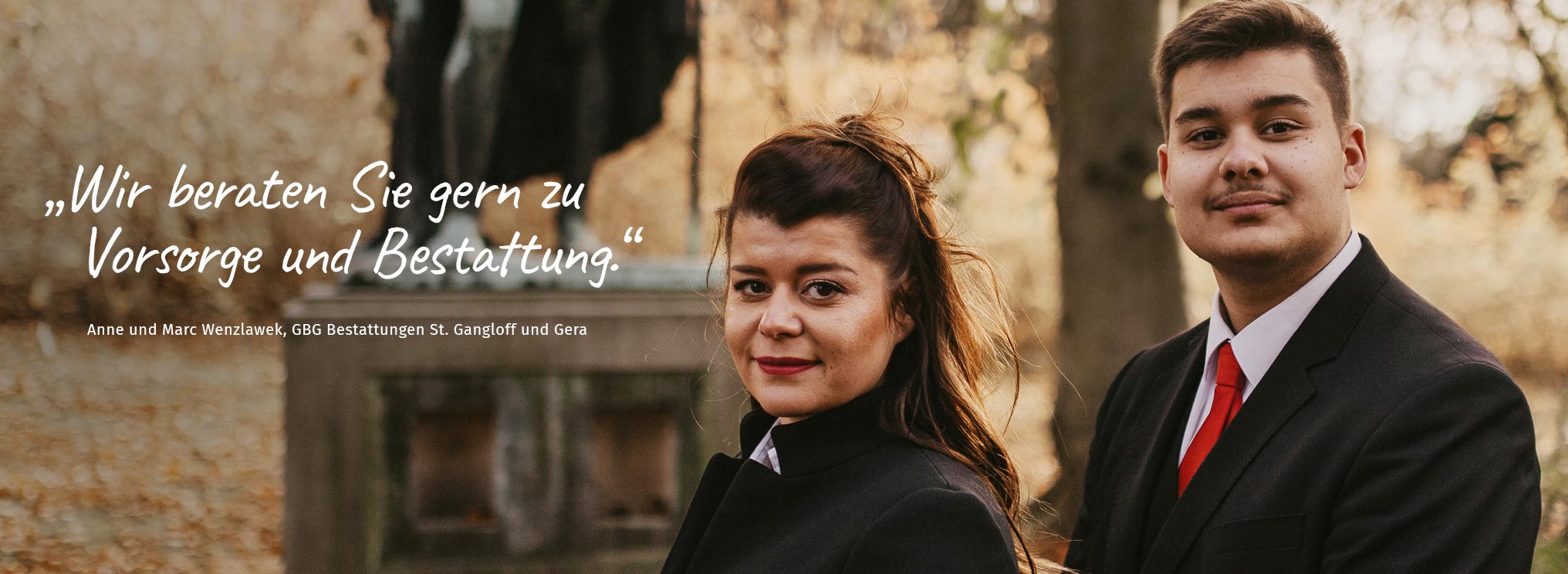 Anne und Marc Wenzlawek von GBG Bestattungen St. Gangloff und Gera stehen in schwarzer Kleidung vor einem Denkmal in herbstlicher Umgebung. Der Text auf dem Bild lautet: „Wir beraten Sie gern zu Vorsorge und Bestattung.“